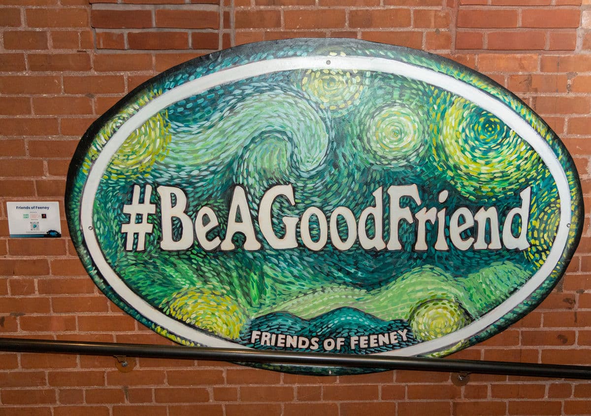 The #BeAGoodFriend mural, a swirling Starry Night–style oval painted in blues and greens on a brick wall