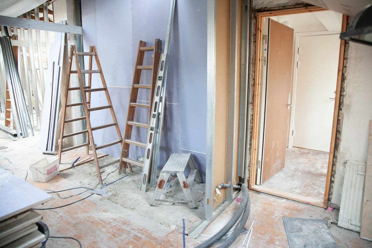Bathroom gutted to the studs with ladders, new drywall and exposed supply lines