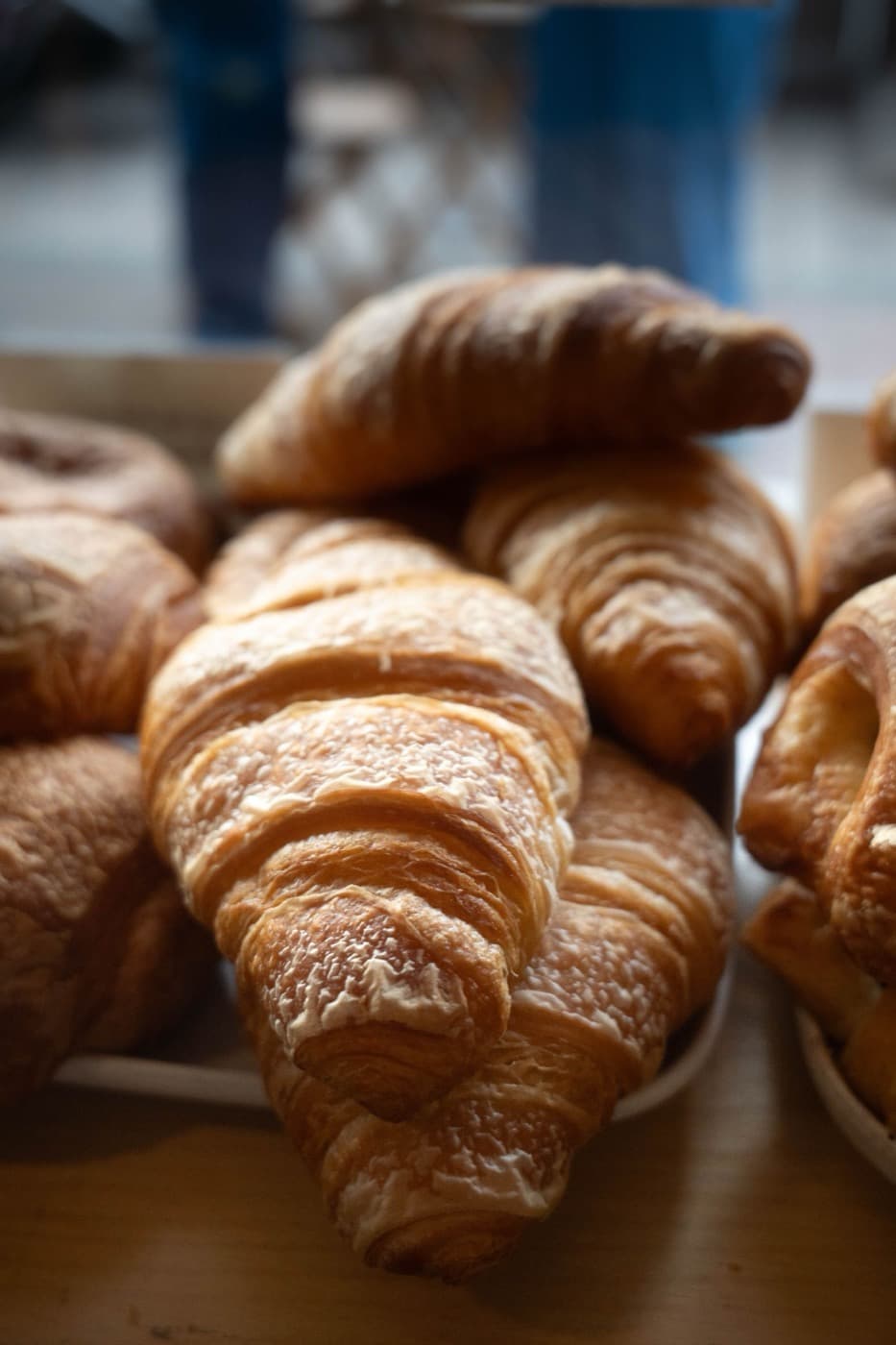 Flaky croissants piled together in soft light